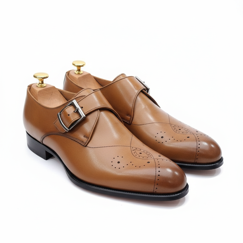 Chaussures monk strap tan avec détails brogues sur fond blanc