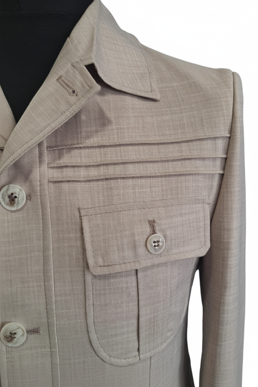 Détail poche poitrine et pinces horizontales de la veste safari beige lin sur fond blanc