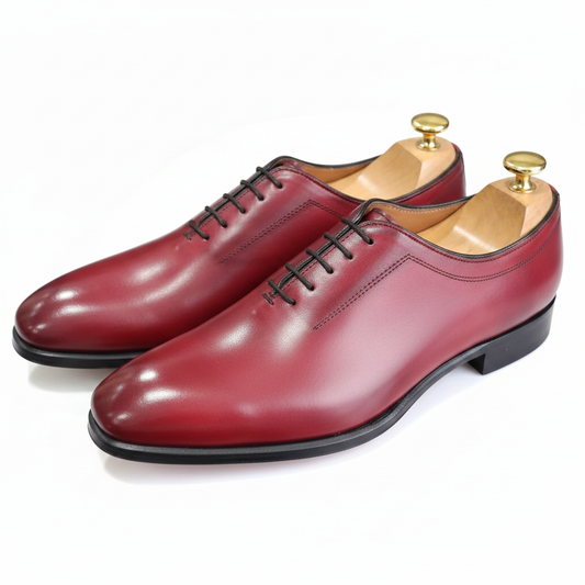 Oxford wholecut bordeaux rouge cerise profond embauchoirs bois boutons laiton fond blanc pur studio ombre légère Berluti Edward Green
