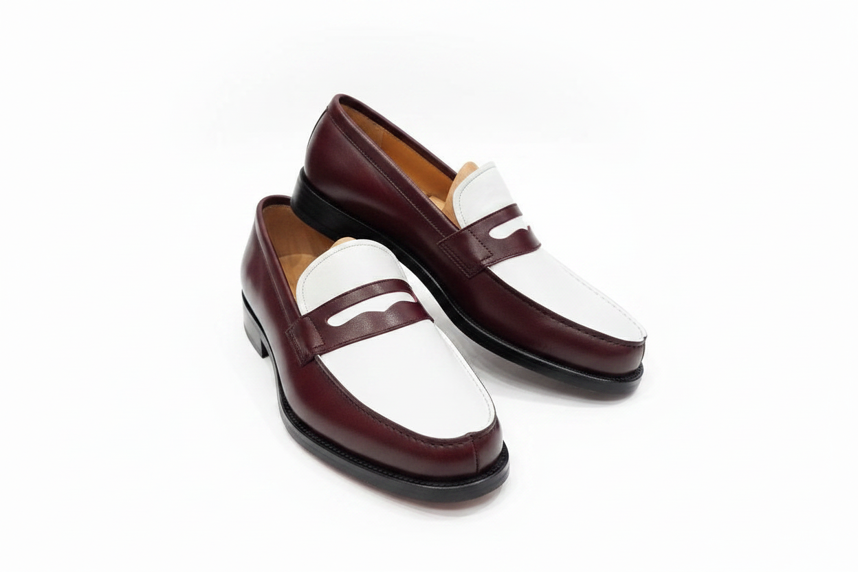 Paire de mocassins bordeaux blanc vue trois-quarts avant sans embauchoirs sur fond blanc pur